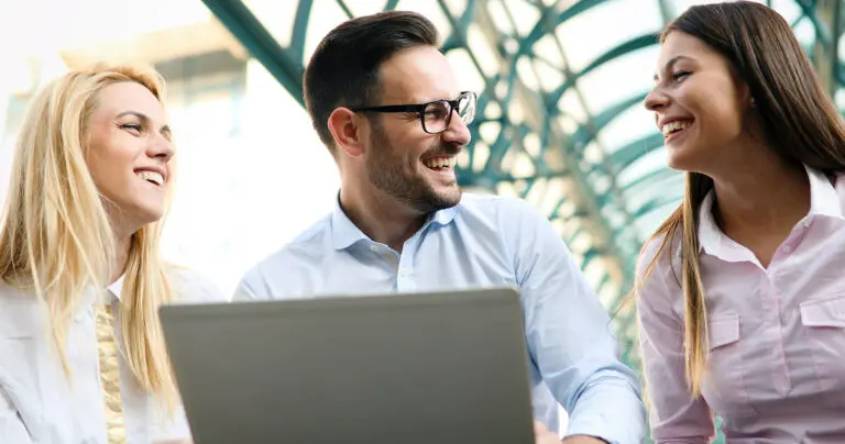 Humor in ads: colleagues watching a funny video on a laptop