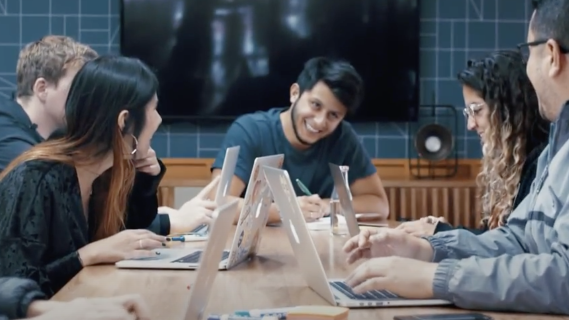 Voice123 employees working together on their laptops