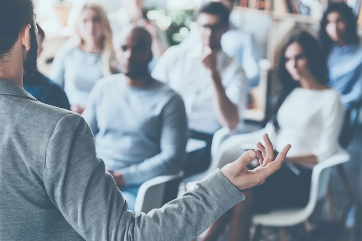 Business presentation scripts: image of man presenting in front of an audience
